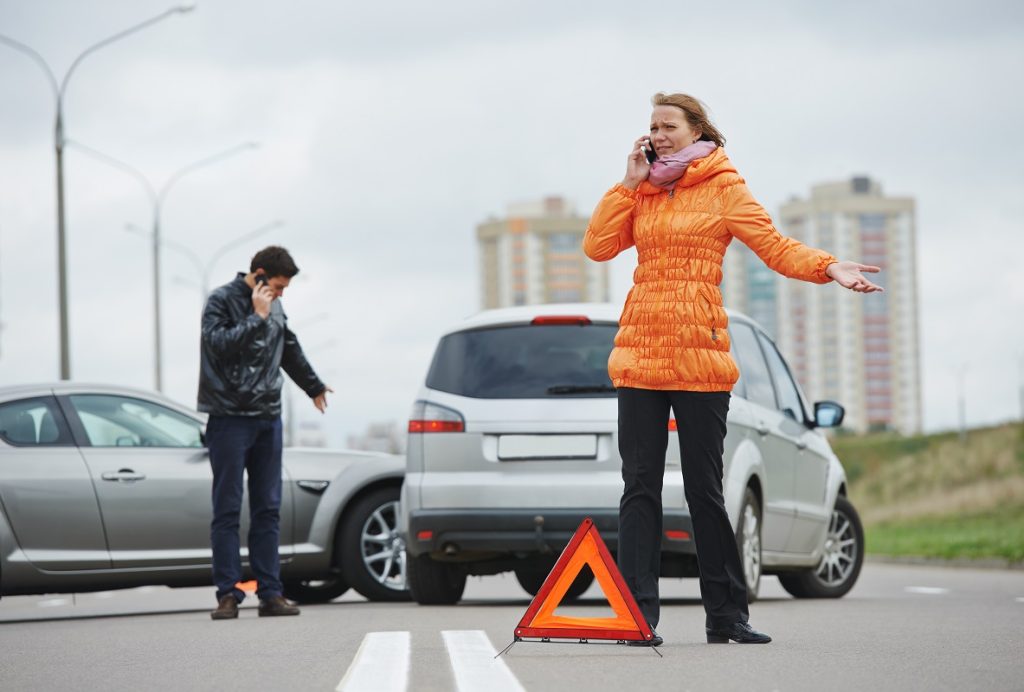 Two people involved in a car accident calling someone on their phone